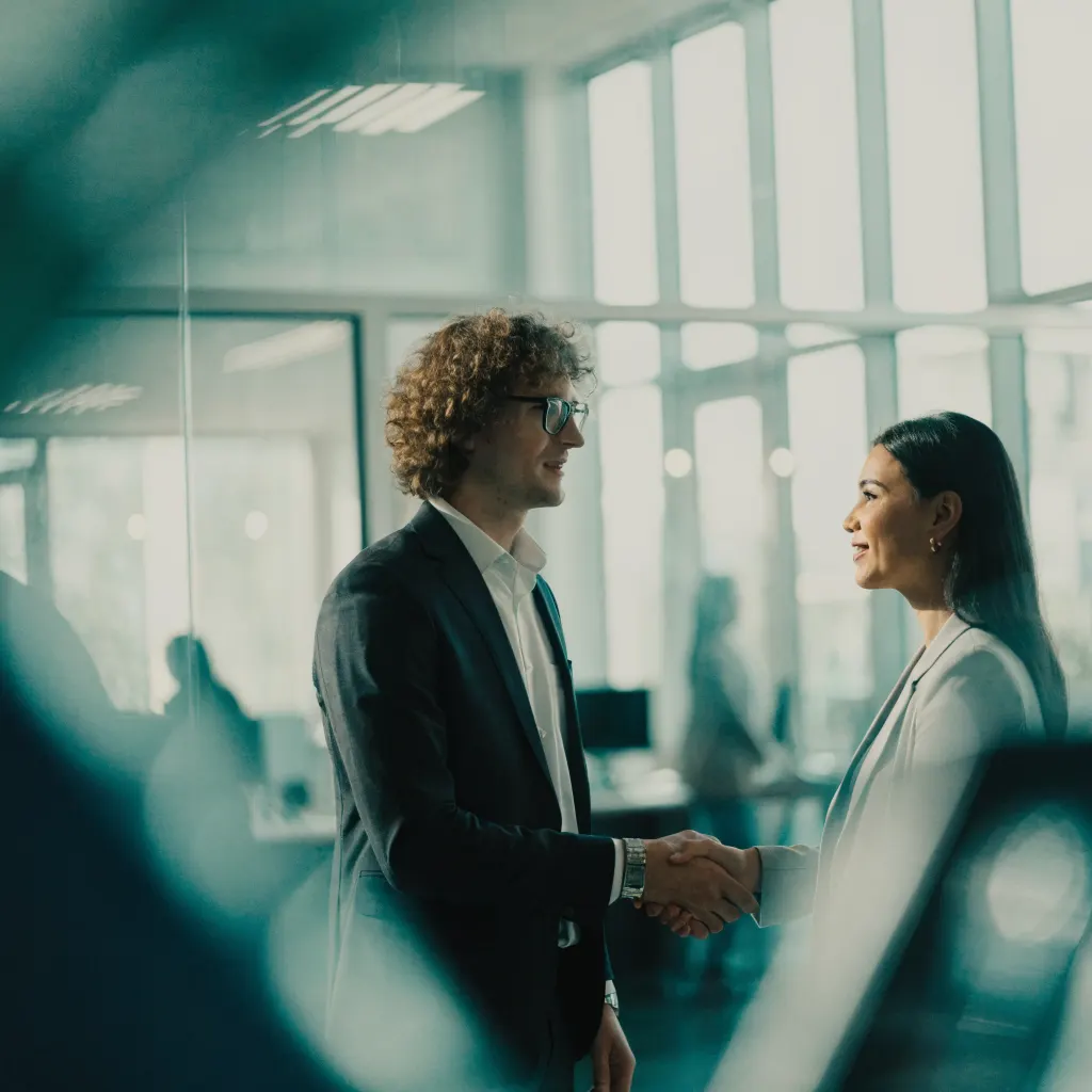 Two business colleagues shaking hands in a modern office